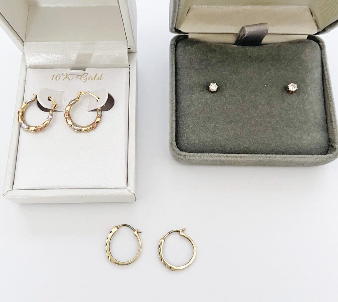 Three Pairs of Petite 14k Gold Earrings: Three pairs of petite gold earrings, includes diamond studs with one small diamond measuring approximately 0.10 carat, stamped 14k, and two pairs of 10k two tone gold hoops, each 1/2" long and stamped