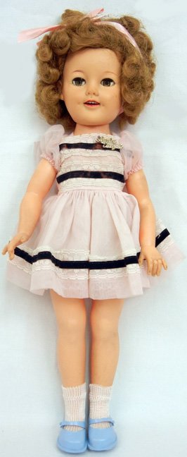 1957 Ideal Shirley Temple, 17", wearing a Shirley: 1957 Ideal Shirley Temple, 17", wearing a Shirley Temple dress, with an original script pin, flirty eyes, hard plastic, marked on back of head