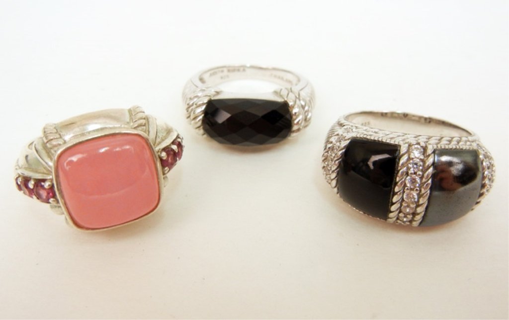 Three Judith Ripka sterling silver rings with stones in: Three Judith Ripka sterling silver rings with stones including one with large pink square stone with pink stone accents on sides, 5/8" long at center, size 9, one with faceted black stone, 1/4" wide a