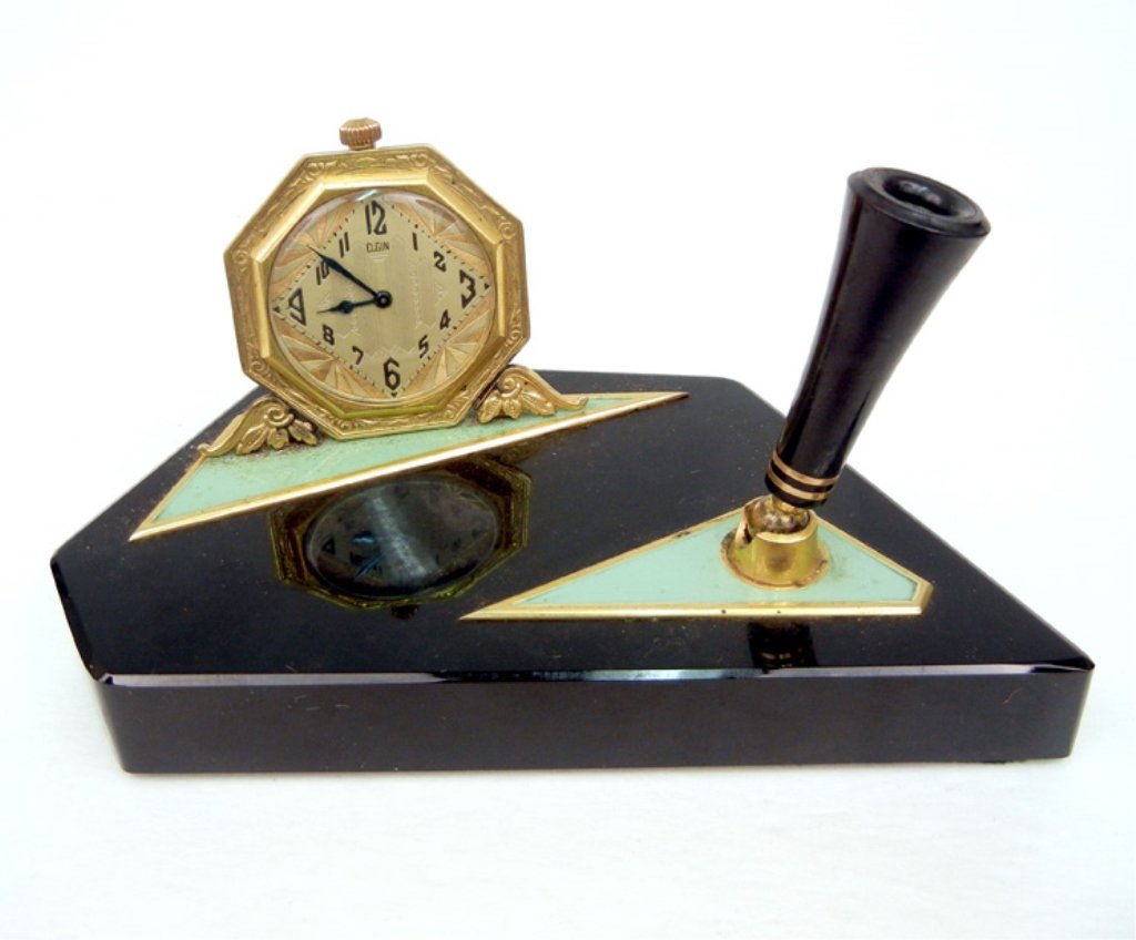 Art Deco desk clock with pen holder, black glass base w: Art Deco desk clock with pen holder, black glass base with octagonal Elgin clock and pen holder on swivel base, raised accent panels enameled in green, base measures 6" long x 3 1/8" wide x 3/4" high,