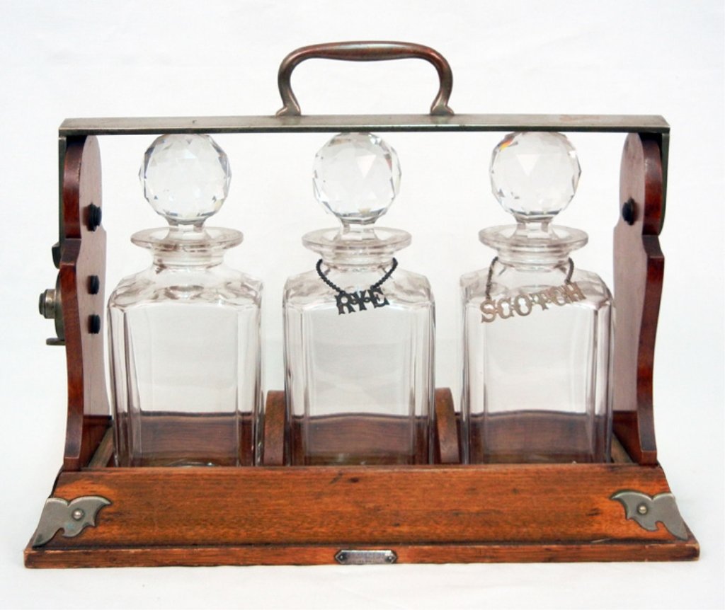 J.C. Vickery oak cased "The Tantalus" set, three cut gl: J.C. Vickery oak cased "The Tantalus" set, three cut glass bottles, silver plated handle impressed "The Tantalus", two bottles with sterling hang tags (only one is removable), .295 troy oz. on one han