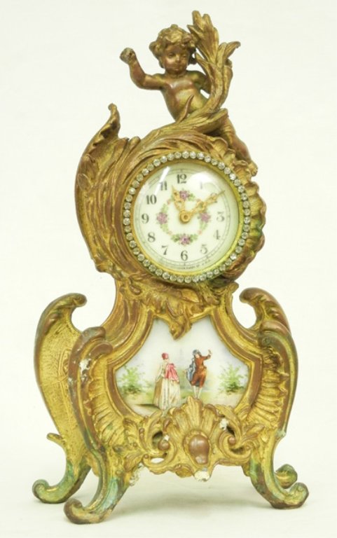 New Haven mantle clock, gilt painted spelter case with : New Haven mantle clock, gilt painted spelter case with cherub finial, rhinestones around glass over painted celluloid dial, porcelain panel on front, 13" x 6 1/2" x 3"