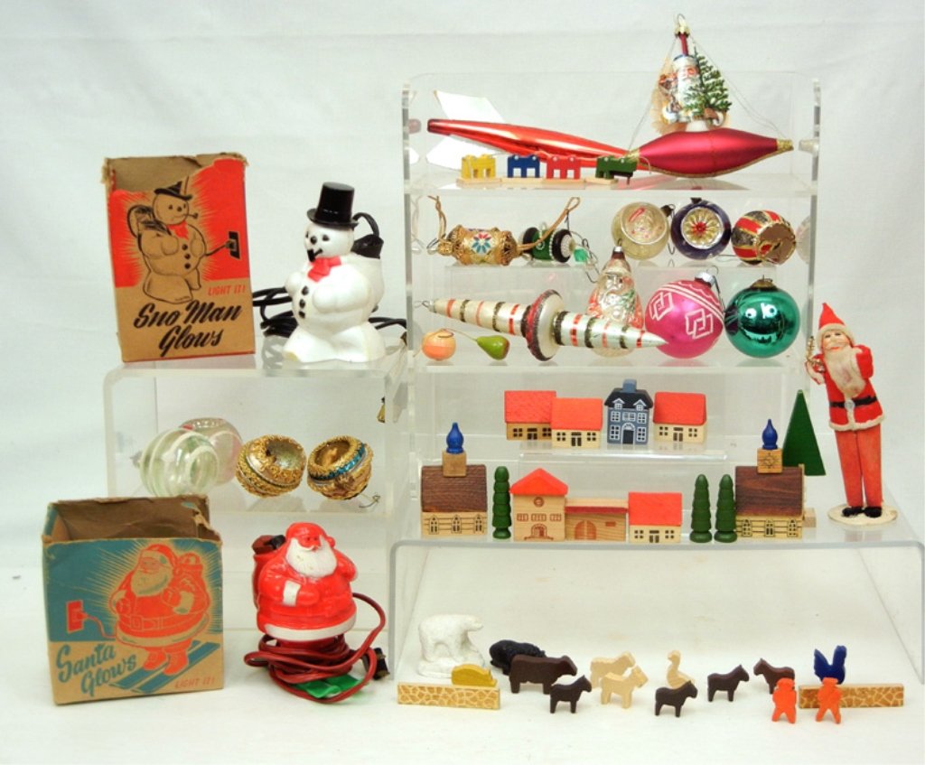 Grouping of German and other Christmas items: Grouping of German and other Christmas items, some wooden buildings, fences, trees, and animals, Snow Man Glows and Santa Glows lights in original boxes, green Kugel, some glass ornaments, and more