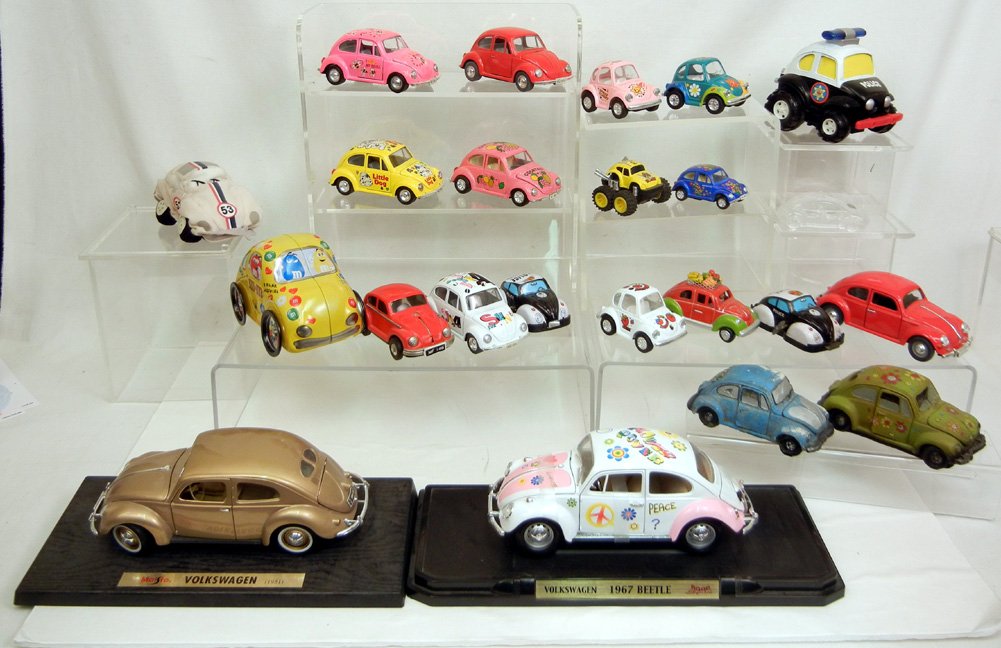 Grouping of twenty-three scale model Volkswagen Beetles: Grouping of twenty-three scale model Volkswagen Beetles, includes Maisto,and Road Signature on bases, two Yone wind-up police cars, Mikasa crystal car, M&Ms tin container, Kintoy, Walt Disney plush, P