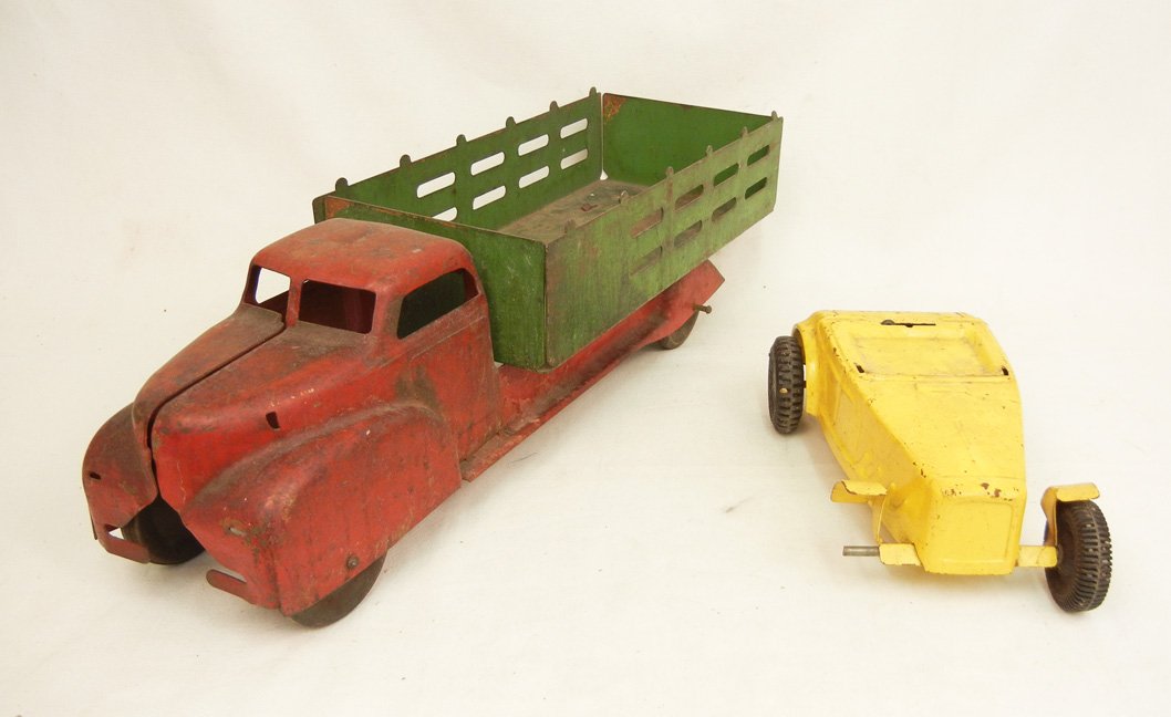 Two pressed steel trucks, early Marx stake truck,: Two pressed steel trucks, early Marx stake truck, 6" x 20" x 6", and a Buddy L sports car painted yellow, 3 1/4" x 9 1/2" x 5 1/4"
