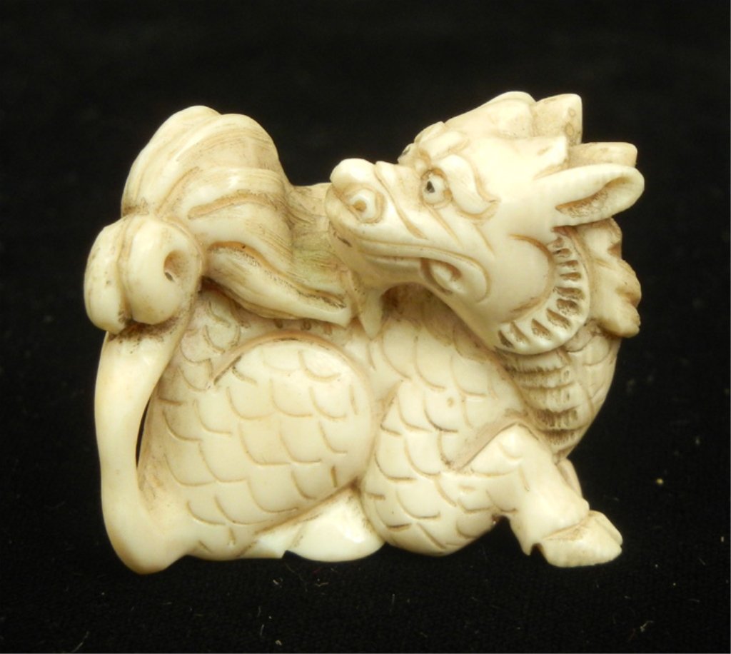 Hand carved ivory netsuke: Seated dragon, hand colored, signed, 1 3/8" long