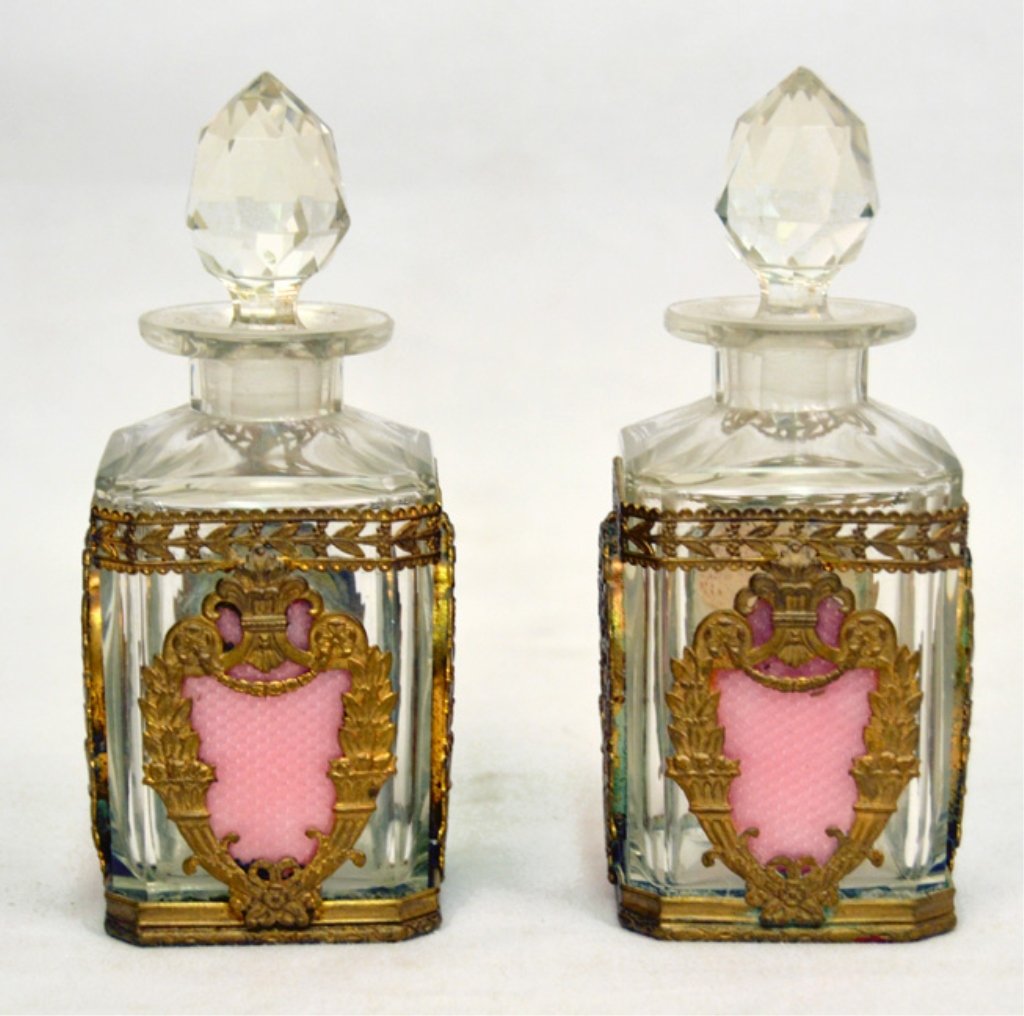 Pair of French crystal perfume bottles: Two matching crystal perfume bottles with brass ormolu, pink guilloche enameled cartouche on four sides, faceted stopper, 5 1/2" high, marked Made in France on metal, ca. 1920
