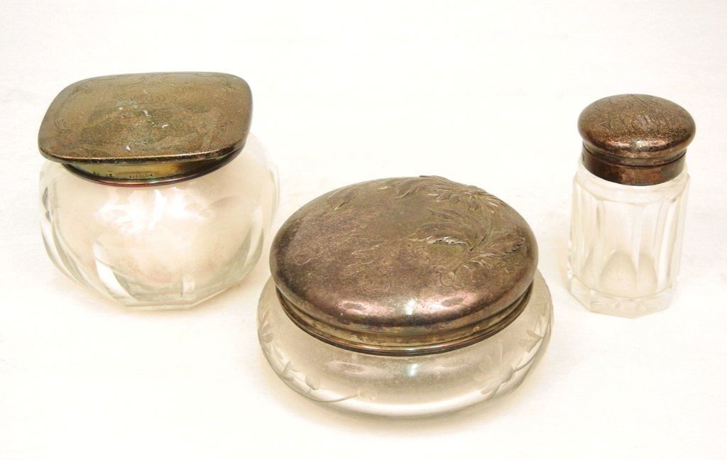 Three silver topped crystal dresser jars: Lot of three dresser jars include one powder jar with puff and screen, nine paneled sides, 3" high, engraved lid with monogrammed initials, lid marked Sterling 9903-41, maker's marks, unreadable; seco