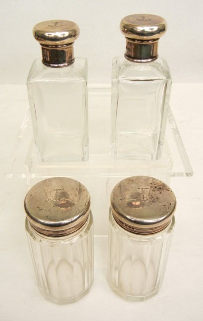 Four sterling silver topped vanity bottles: Set of four crystal bottles include one pair 3 3/4" high, cork lining in lids, and one pair of bottles with paneled sides, 3 1/2" high, all four tops marked with English sterling silver hallmarks, W.