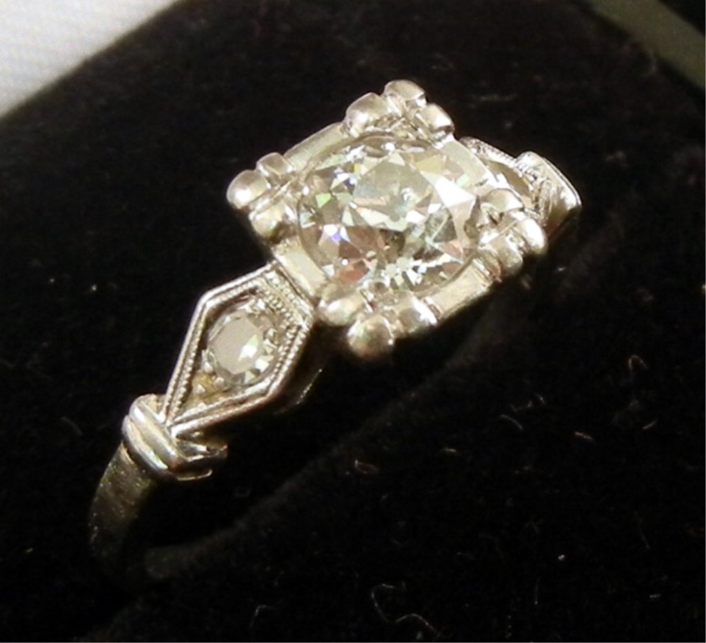 Platinum and diamond solitaire engagement ring: Round old European cut center stone measuring approximately 0.65 carats with one 5 point diamond in either side, square mounting, size 6 3/4, marked platinum, weight 4.4 grams/2.8 dwt, early 20th C.