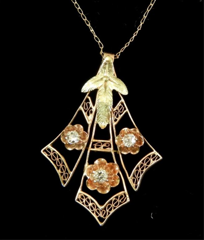 Edwardian two toned gold and diamond filigree necklace: 14k rose gold filigree pendant with green gold leaves, three round diamonds measuring approximately 0.05 carats in buttercup mountings, pendant measures 1 1/8" long, 18" fine link chain marked 14k, we