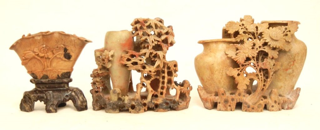 Grouping of carved soapstone vases: Grouping of carved soapstone vases, including a double vase with floral design, 6" high, vase with tree design, 6", and a smaller vase with floral design, mounted on footed base