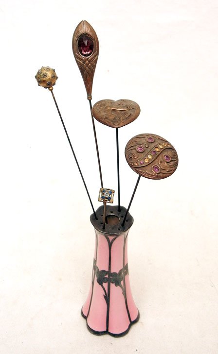 Hat pins with holder: Porcelain hat pin holder, pink with sterling silver overlay in floral motif, 5" high, with five brass hatpins including one with heart shaped top, Art Nouveau repousse motif with woman riding seahorse