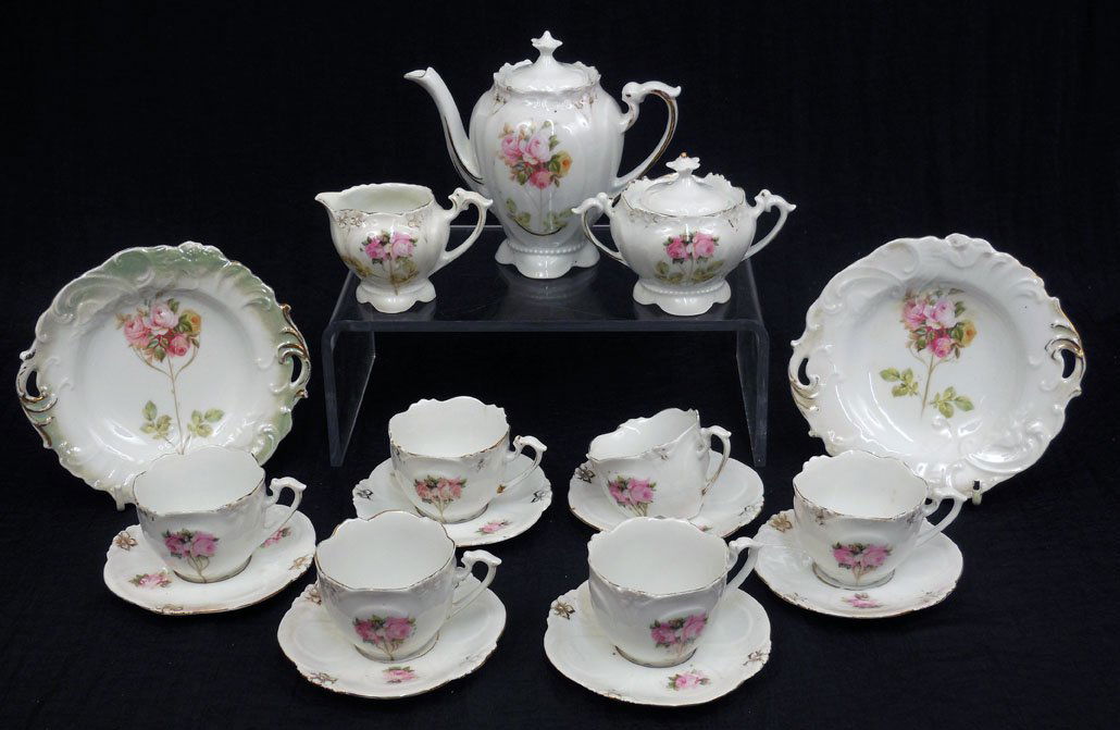Child's German porcelain tea set: Child's German porcelain tea set, rose and gilt design, including tea pot, 5", creamer 2 1/8", sugar bowl 3", two cake plates 5 1/2", six tea cups 1 1/4", and six saucers 3 3/4", lid doesnâ€™t fi