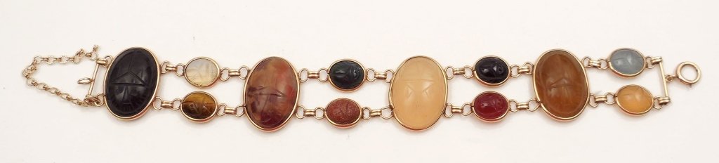 Gold scarab bracelet: 14k gold scarab bracelet with four large stones measuring 1" long x 3/4" wide and eight smaller stones measuring 1/2" long x 3/8" wide, stones include agate, goldstone, bloodstone, moonstone, tigers e