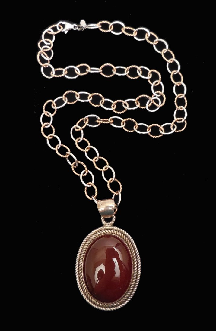 Sterling silver carnelian necklace: Sterling silver link chain with oval carnelian pendant set in sterling silver, pendant measures 2 5/8" long from top of bale x 1 5/8" wide, 23" long chain, alternating links with rose gold wash, chain