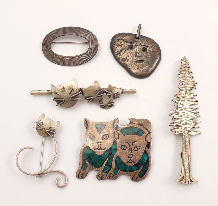 Modern sterling silver jewelry grouping: One lot of five sterling silver pins and a handmade face pendant, 1 3/8" wide, marked Conrad Gersu Sterling, pins include two Beau Sterling cat pins, Beau Sterling oval pin, tall pinetree pin signed J