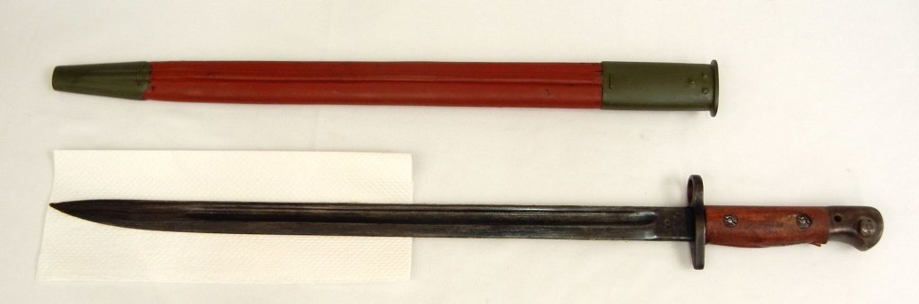 British 1907 pattern bayonet: British 1907 pattern bayonet in scabbard by Wilkinson, maker's mark on right ricasso, left ricasso with broad arrow and inspection marks for Enfield, in painted leather and brass scabbard, scabbard im