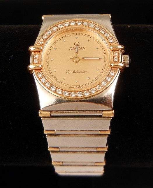 Lady's Omega Constellation wristwatch: Lady's Omega constellation wristwatch with diamond bezel, stainless steel band with gold accents, round face is 7/8" in diameter, Bezel is set with thirty two round diamonds measuring 0.015 carats eac