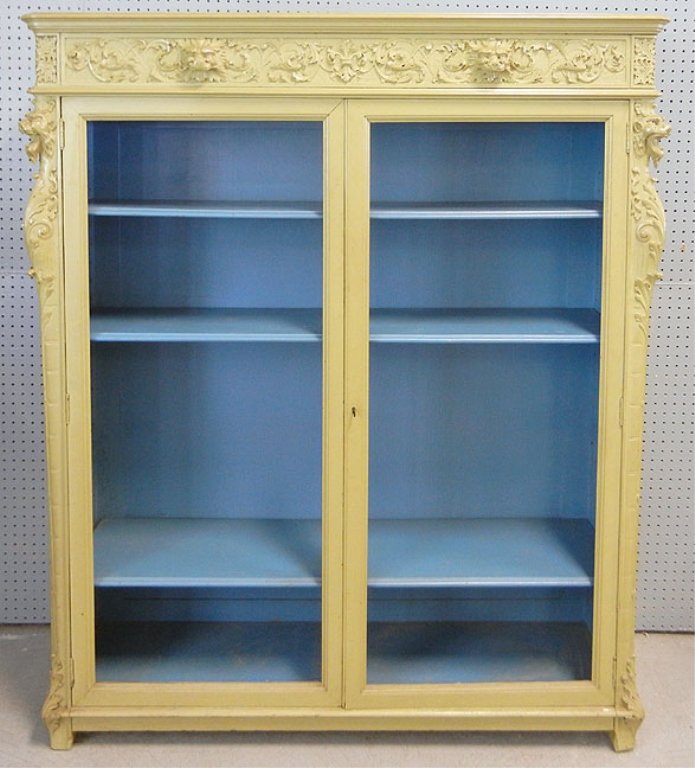 Painted oak two door bookcase: Painted oak two door bookcase, gargoyle mask decoration on cornice and top of side columns, acanthus leaf decoration at bottom of columns, three interior shelves, 62 1/2" high x 53 1/2" x 15 1/2"