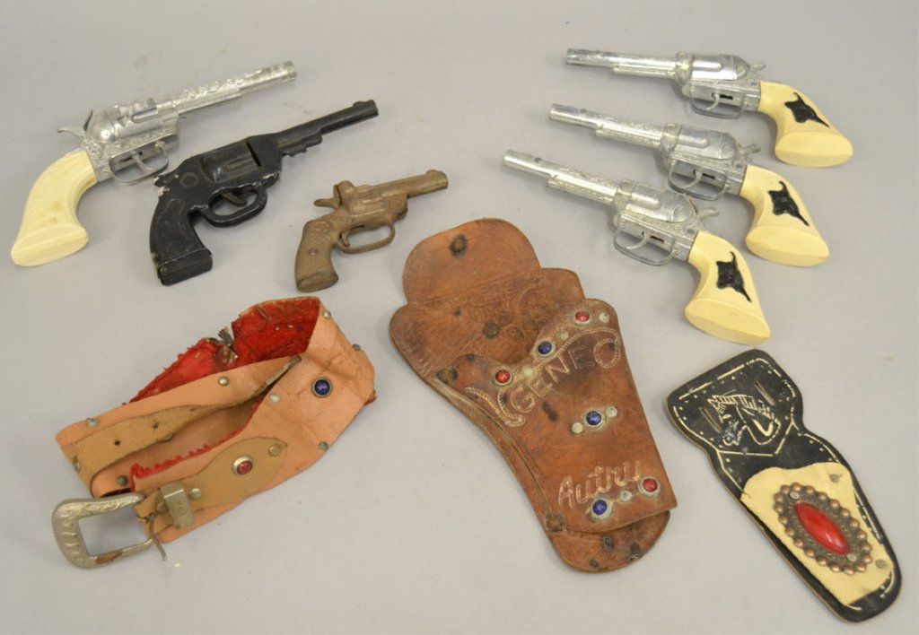 Vintage toy cap guns, including Hubley: Vintage toy cap guns, including three Hubley Texan Jr's #250R, 9" across, Pony Boy, 9 1/4" across, black tin litho toy hand gun, unmarked, 8" across, and a small cast iron gun, marked Safety on both s