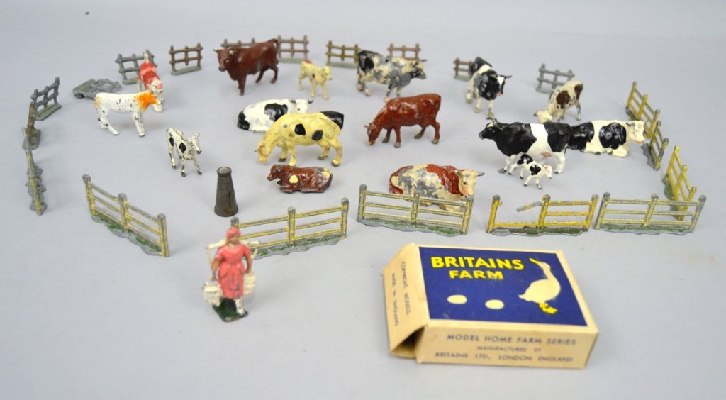 Grouping of miniature painted metal farm animals: Grouping of miniature painted metal farm animals, includes 16 cows, some marked Britains, some Hill, most marked England, 19 fence sections, metal bottle, and Milk maid in original box, Britains Farm