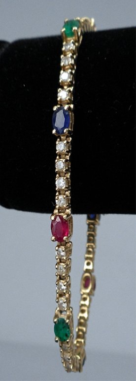 Gold bracelet with precious stones: 14k gold ruby, sapphire, emerald and diamond bracelet, 7 1/2" long x 3mm wide, four oval sapphires, three rubies and three emeralds each measuring 5mm long x 3mm wide, forty round diamonds totaling ap