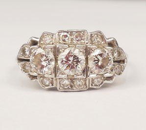 Platinum & diamond ring: Art Deco platinum and diamond three stone ring, center stone measures approximately 0.40 carats with one 0.25 carat diamond on either side, twelve one point diamonds on border, size 11, stamped 10% Ir