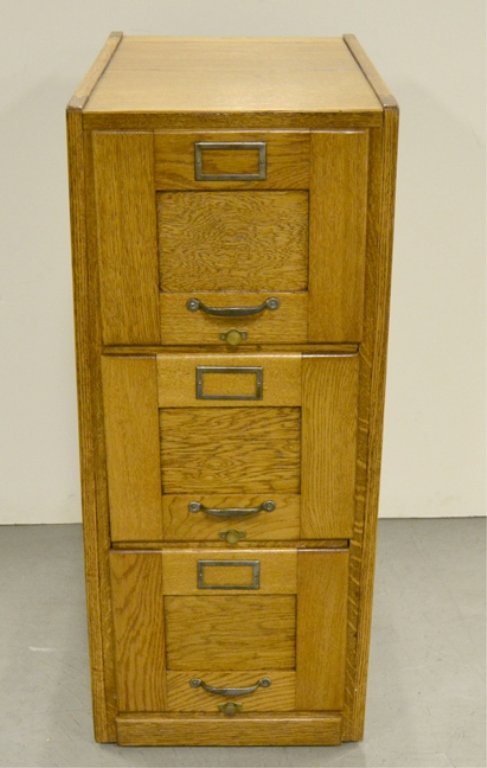 Oak three drawer file cabinet: Oak three drawer file cabinet, paneled doors and sides, 39" high x 16 1/2" x 29"