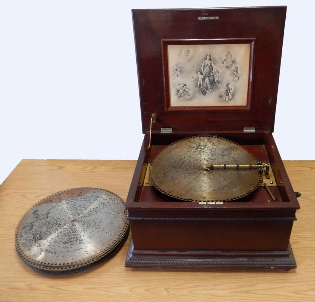 Antique Regina music player with twenty-five discs: Antique Regina music player with twenty-five discs, tabletop player, plays 15 1/2" discs, hinged lid, marked "Copyright 1896 by the Regina Music Box Co." on print underside of lid, with Regina plaque,