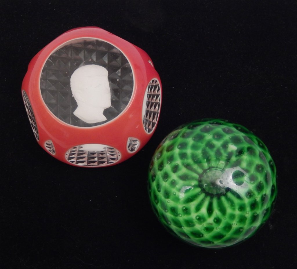 Two art glass paperweights: Two art glass paperweights, includes sulfide John F. Kennedy paperweight, clear glass with red and white double overlay, unsigned, 2" high x 3" diameter, and one with green floral design, paper label 