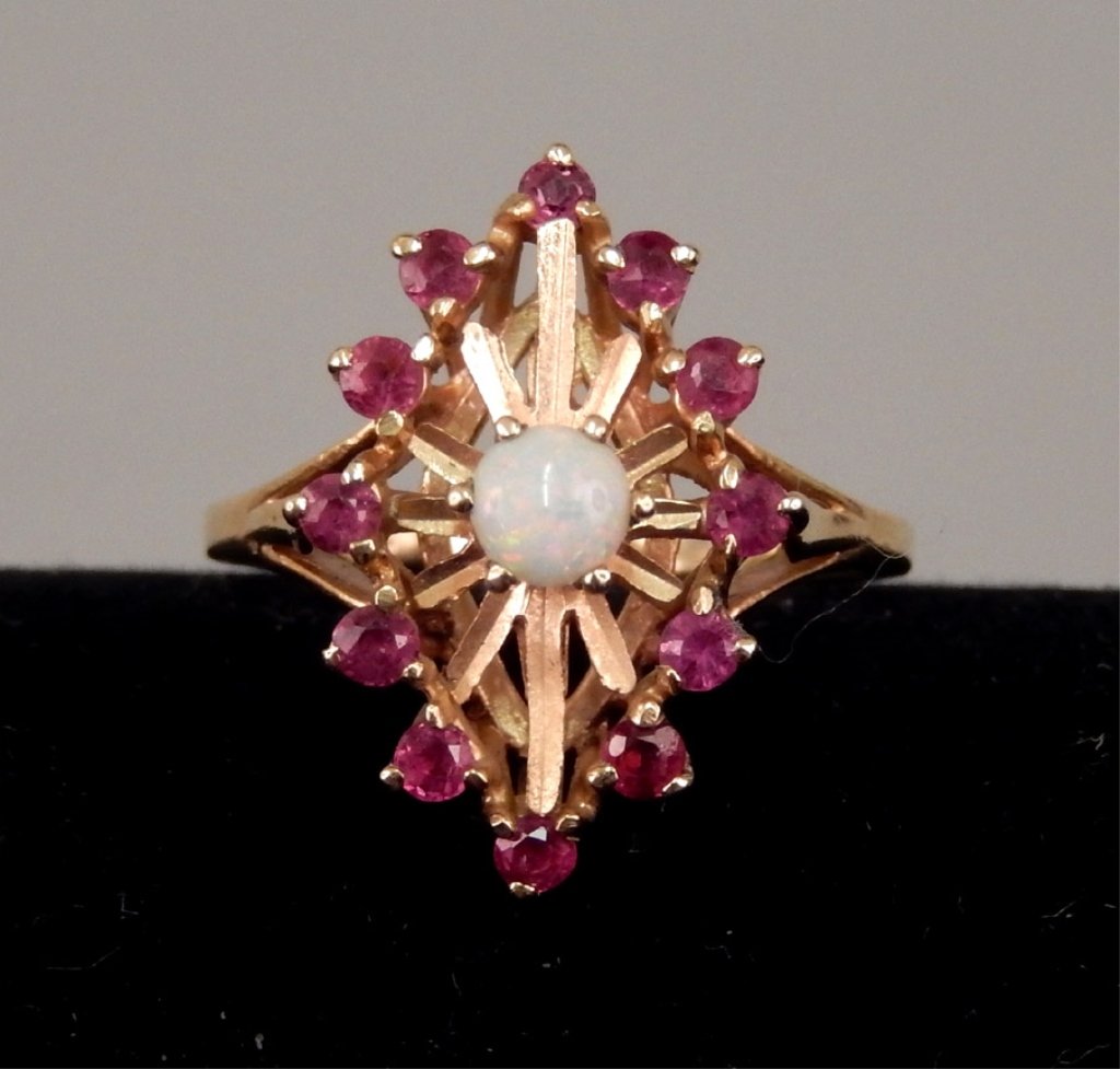 10k gold opal and ruby starburst ring: 10k gold opal and ruby ring with starburst design, opal measures approximately 3mm across surrounded by twelve rubies, size 5, stamped 10k, weighs 3.5 grams/2.2 dwt, mid to late 20th C