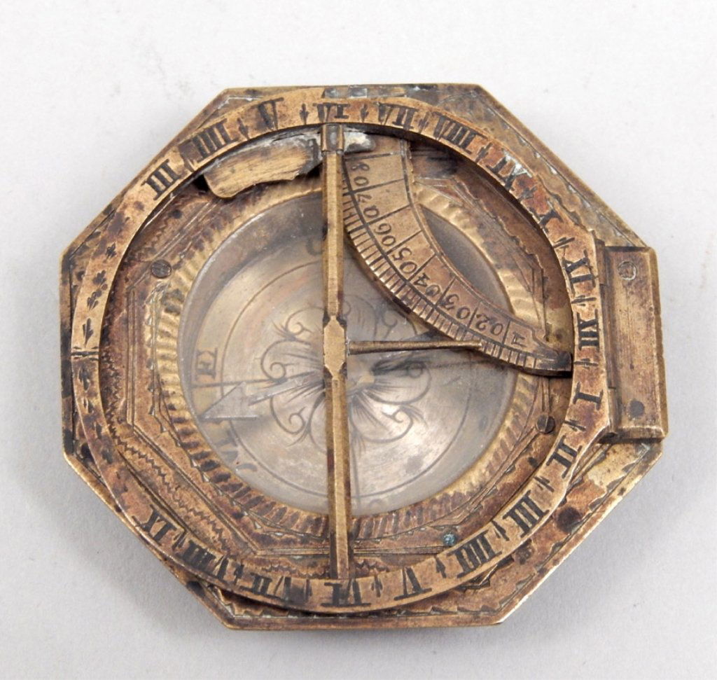 Brass universal equinoctial sundial: Brass universal equinoctial sundial, octagonal surround with hinged hour circle and Roman numerals, latitude arc engraved from 0-80, 1 1/8" diameter sunken silvered compass dial with directional marki