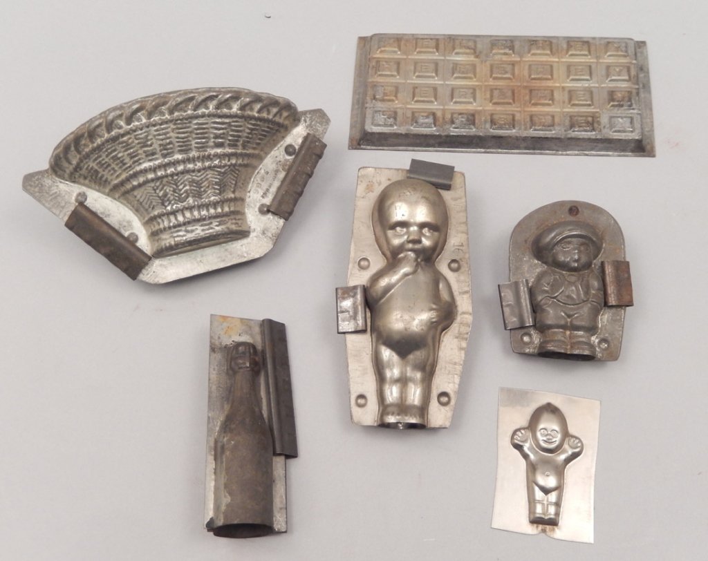 Grouping of chocolate molds: Grouping of chocolate molds, six total, includes Hershey's, 3 1/2" x 7 1/2", three figural molds, boy wearing hat marked Made in Germany, 3", 3 1/2", and 6" high, one in the shape of a bottle, 4 1/2",