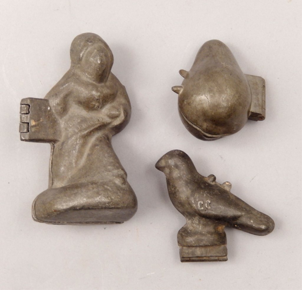 Three pewter ice cream molds: Three pewter ice cream molds, includes robed figure, embossed E. & Co., 981, Des. Coprd 1890, 5 1/4" high, French perched bird, embossed CC on both sides, 3 1/4" high, and a pear shaped mold, by C & G