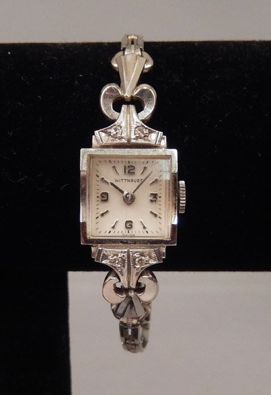 Wittnauer 14k gold and diamond watch: Wittnauer 14k white gold and diamond ladies wristwatch with Gemex silvertone band, case measures approximately 15mm x 12mm, stamped 14k, mid 20th C. Watch currently running.