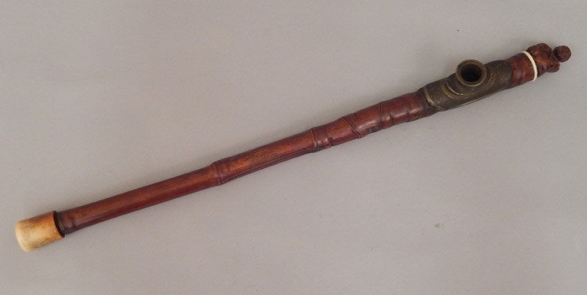 Carved bamboo opium pipe: Carved bamboo opium pipe, carved seated man at end, metal bowl, 20" long