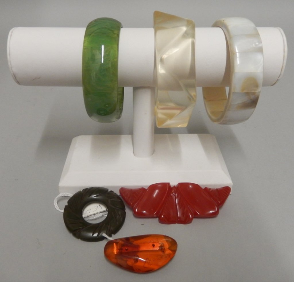 Three bakelite pins and three bangles: Three bakelite pins and three bangles, red bakelite leaf pin, root beer bakelite pin, round green bakelite pin, mother of pearl bangle, green cloudy lucite bangle, and clear lucite bangle