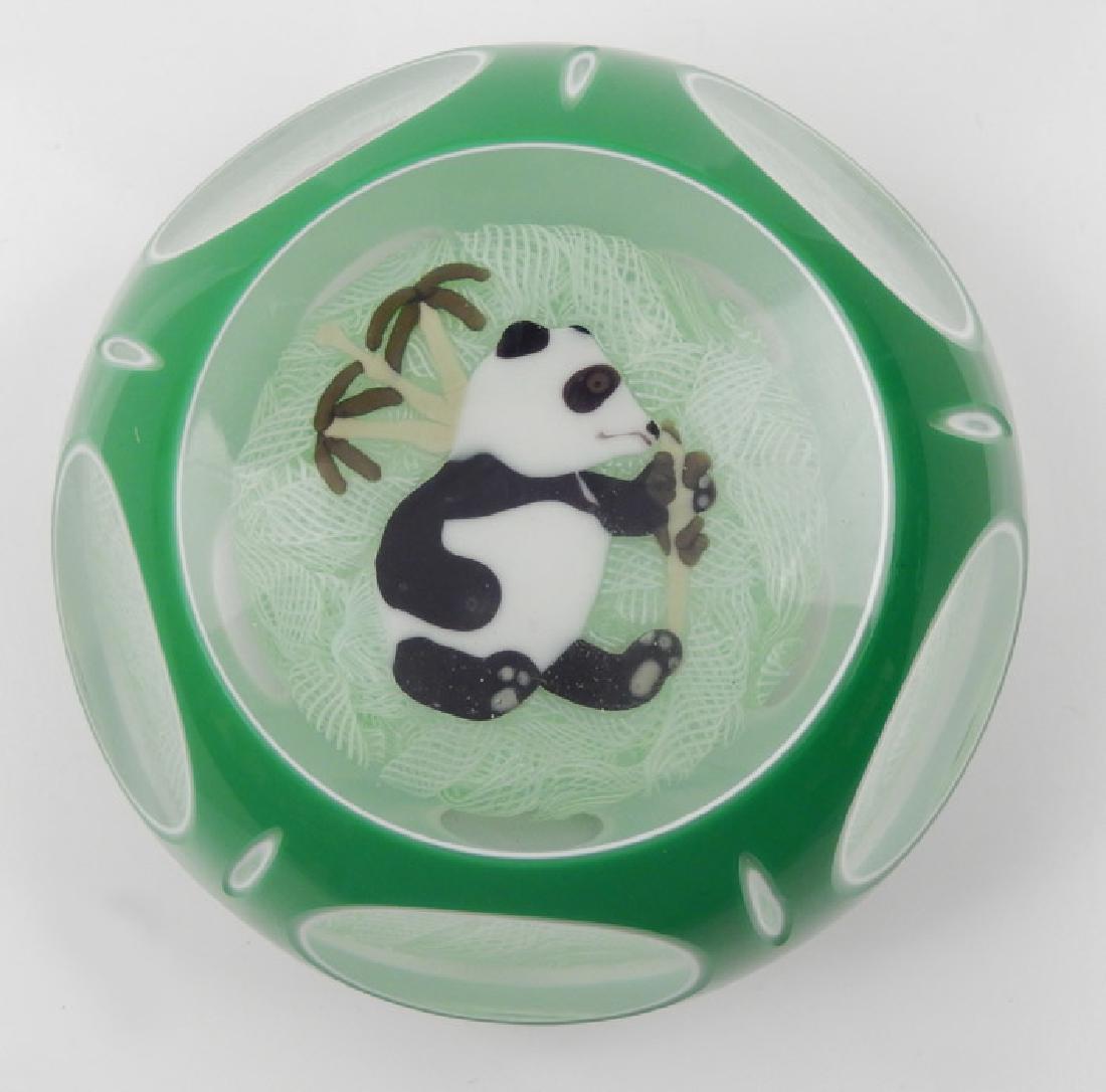 John Deacons art glass paperweight: John Deacons art glass paperweight, green/white double overlay, center panda design, JD signature cane, dated 2005, panda eating bamboo with two bamboo plants behind him, sitting on white muslin groun