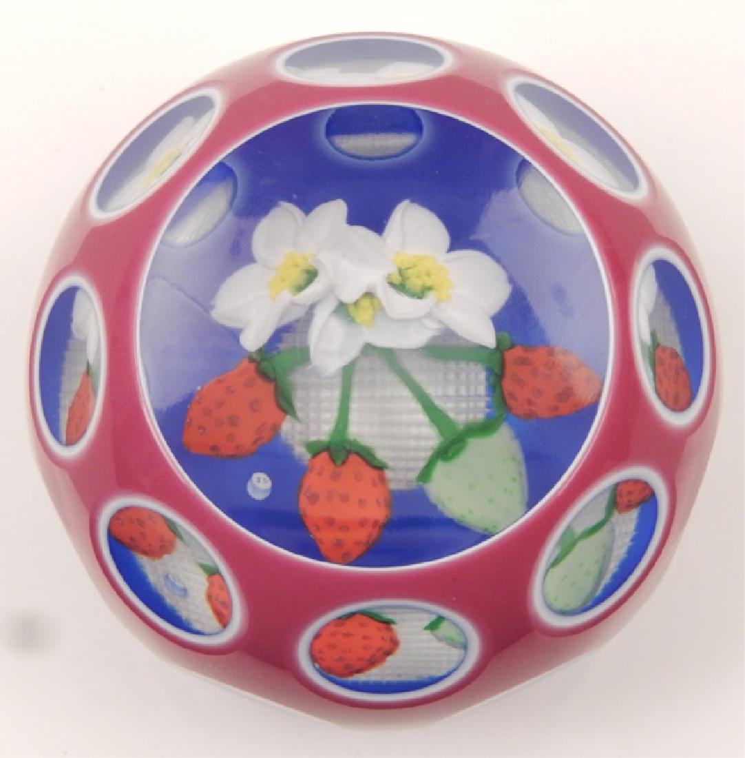 John Deacons art glass paperweight: John Deacons art glass paperweight, triple overlay rose/white/ and blue, three red strawberries and one green strawberry, three white blossoms with yellow and green centers on green stems, base is cro