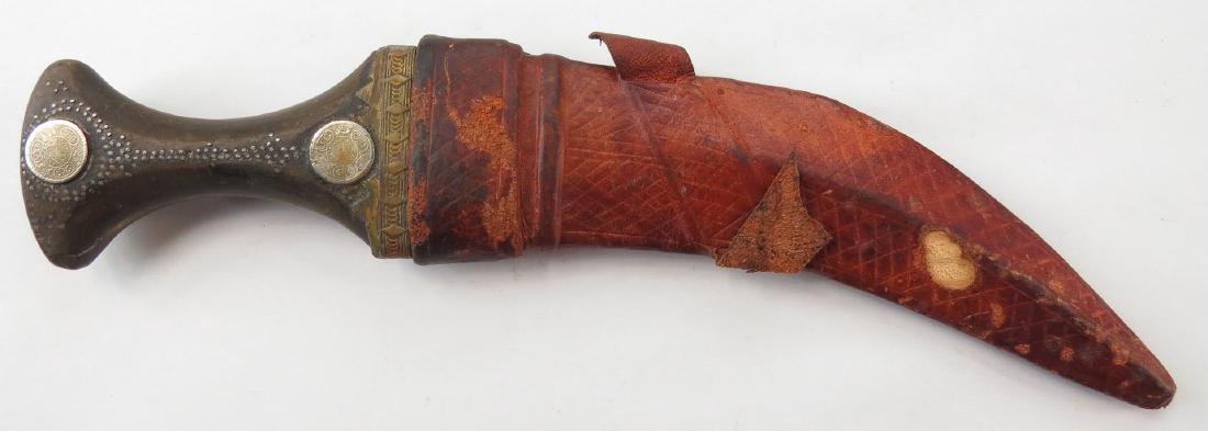 AN ARAB KHANJAR DAGGER: Horn hilt with characteristic curved blade. In its leather-covered wooden scabbard. 20th century._x000D_ Well worn. Overall length 32 cm. Condition IV_x000D_