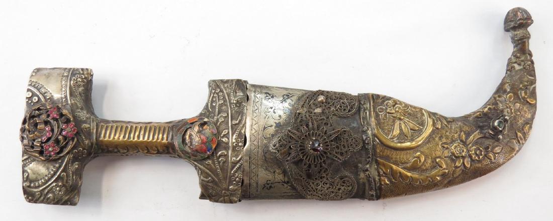 AN OTTOMAN HANCER DAGGER: Embellished with embossed plaques and glass gems, with curved blade. In its en suite scabbard. 19th-20th century. Well worn. Overall length 33 cm. Condition IV