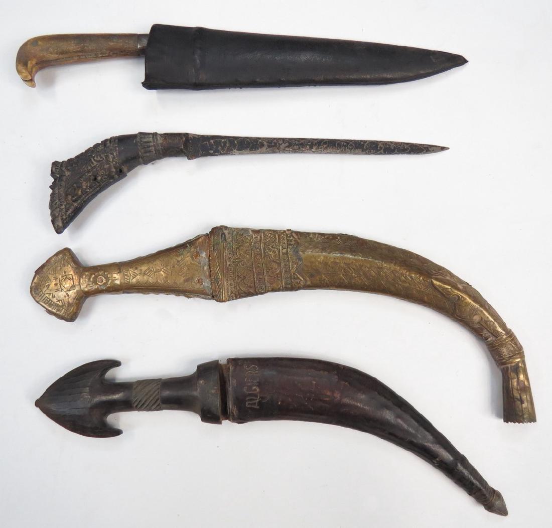 FOUR EASTERN DAGGERS: Including a Kerala knife in sheath, an Indonesian dagger with carved grip, a brass-mounted Arab dagger and an Iraqi dagger with horn grip. 19th-20th century. All as found. Overall length of the longes
