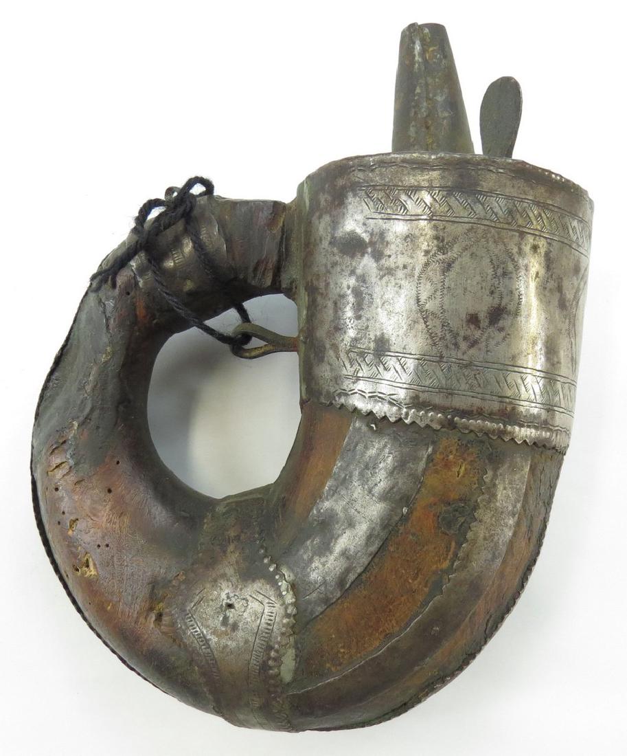 AN OMANI POWDERHORN: Or characteristic form with engraved iron mounts. 19th century. Worn. Overall height 22.5 cm. Condition IV