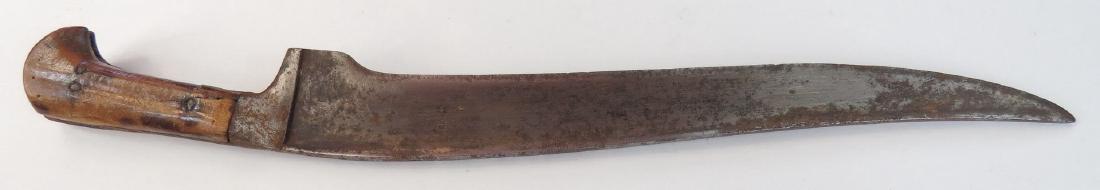 A MUGHAL PESH QABZ DAGGER: Of characteristic form with horn grips and steel bolsters. The handwrought blade broad, T-backed and recurved, with chamfered edge. 18th century. Worn, pitted. Overall length 38.5 cm. Condition IV