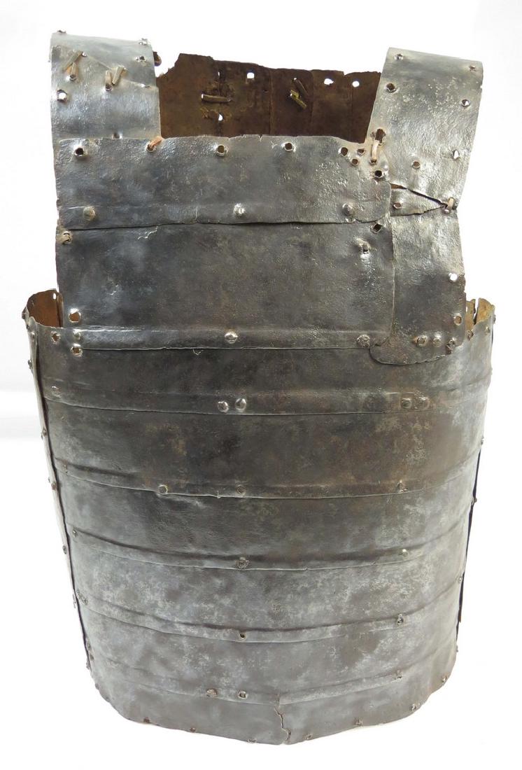 A RARE AFRICAN BODY ARMOR: Bornu work, very seldom-encountered. Of characteristic form, composed of a series of handwrought steel plates connected by rivets, completely covering the torso and shoulders, with applied brass studs