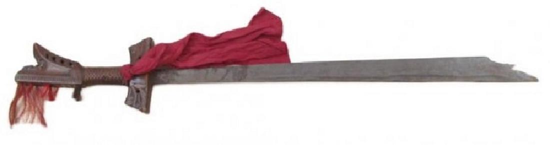 A RARE MORO KAMPILAN SWORD: With well-carved wooden hilt of typical form, the finely-woven rattan grip intact, the bifurcate pommel retaining some red and black hair tassels. The guard carved with scrolls and rare Arabic inscrip