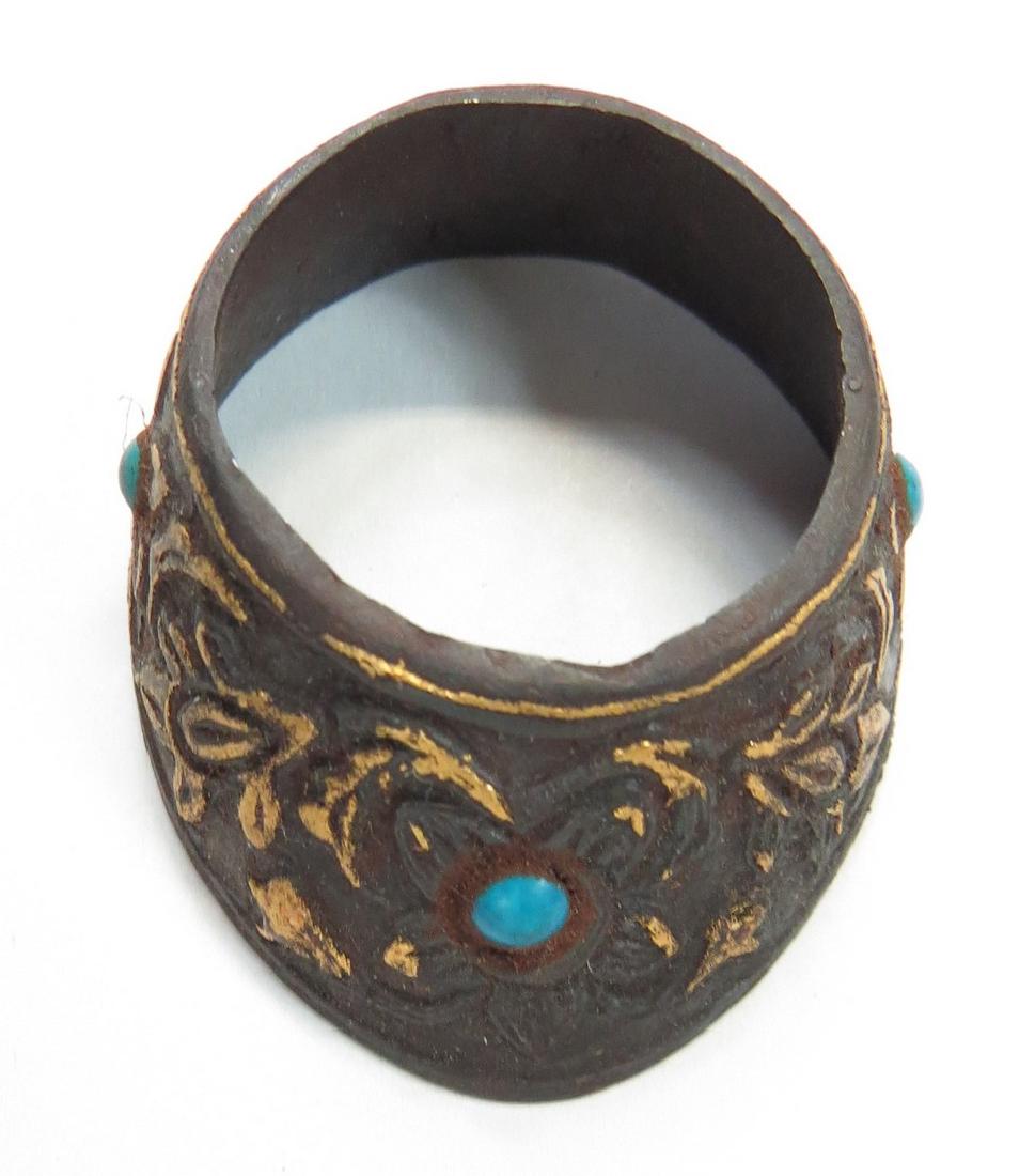 A MUGHAL ARCHERS RING: Handwrought of steel, well-chiseled overall with flowering vines inlaid in gold and set with turquoises. 18th century. Worn. Overall length 4cm. Condition III