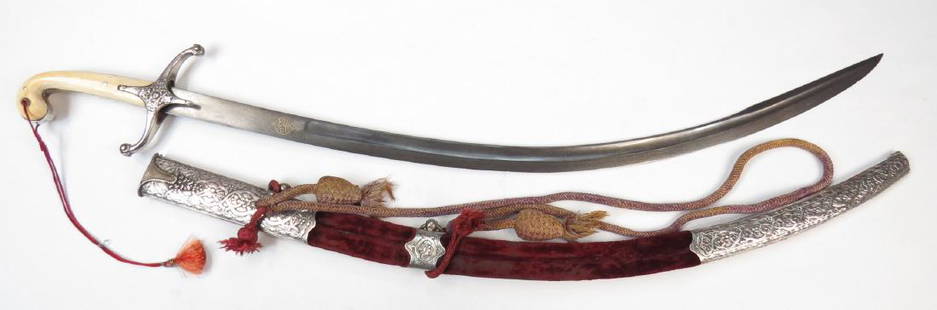 A FINE OTTOMAN KILIC SWORD: A superior example, with elephant grips, the tangband and recurved guard wrought of silver, the guard finely embellished in floral motifs in relief. The blade of characteristic form, broad with shallo