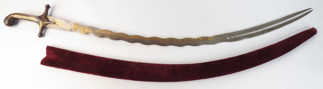A RARE MUGHAL ZULFIKAR SHAMSHIR SWORD: The elegant hilt wrought of steel inlaid overall in gold and silver vinework, the fine, long, undulating, single-edged blade wrought of finely-patterned wootz steel, with characteristic bifurcated and